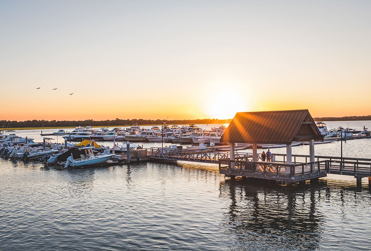 Boats docked at marina at sunset