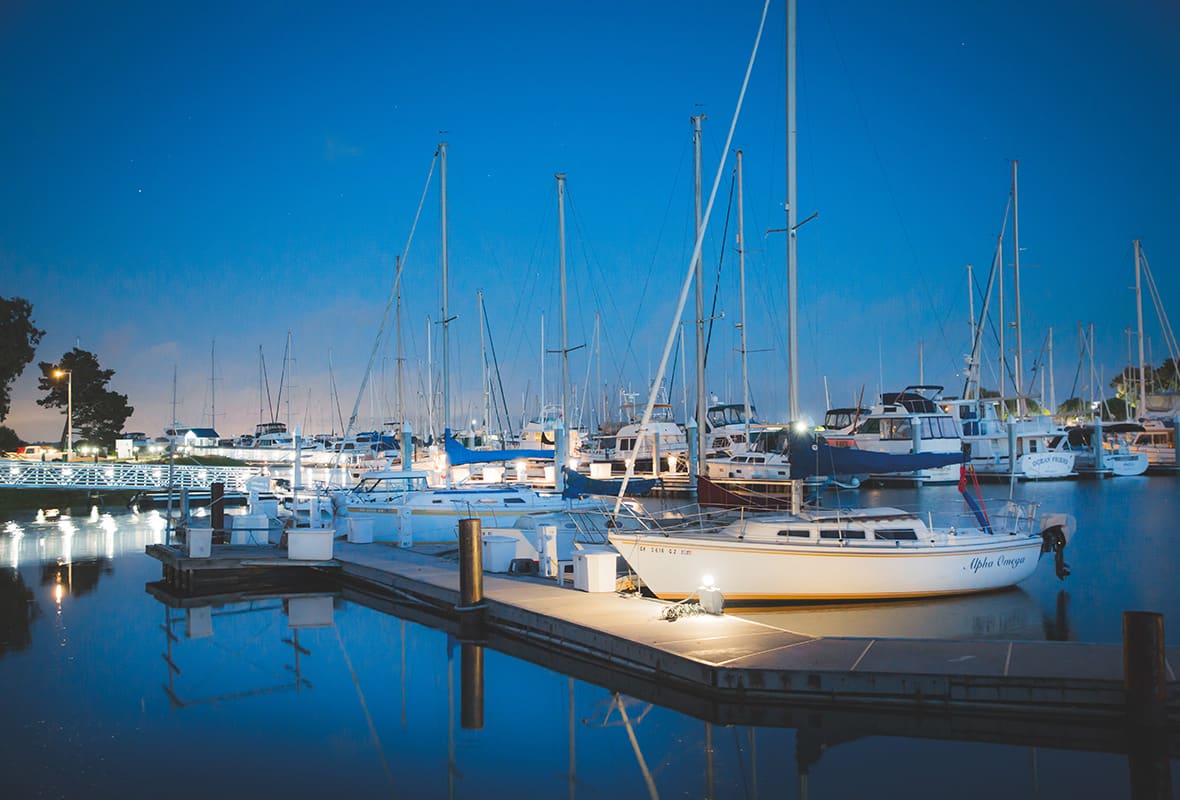 Boats docked at marina at dusk