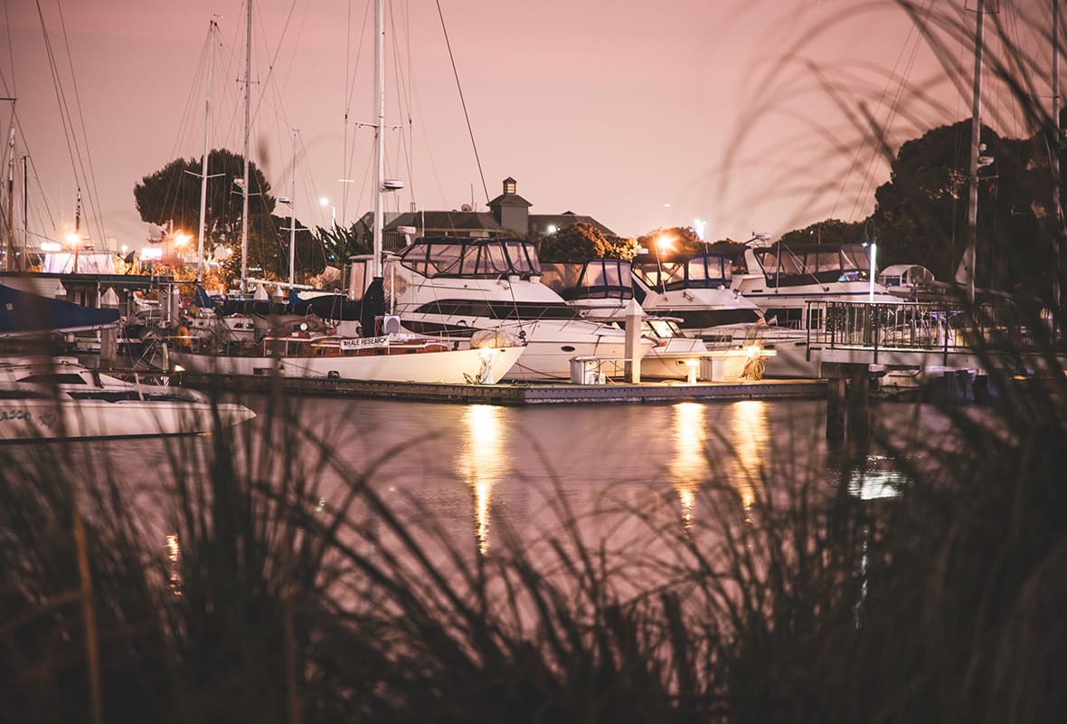 Boats docked at marina at night