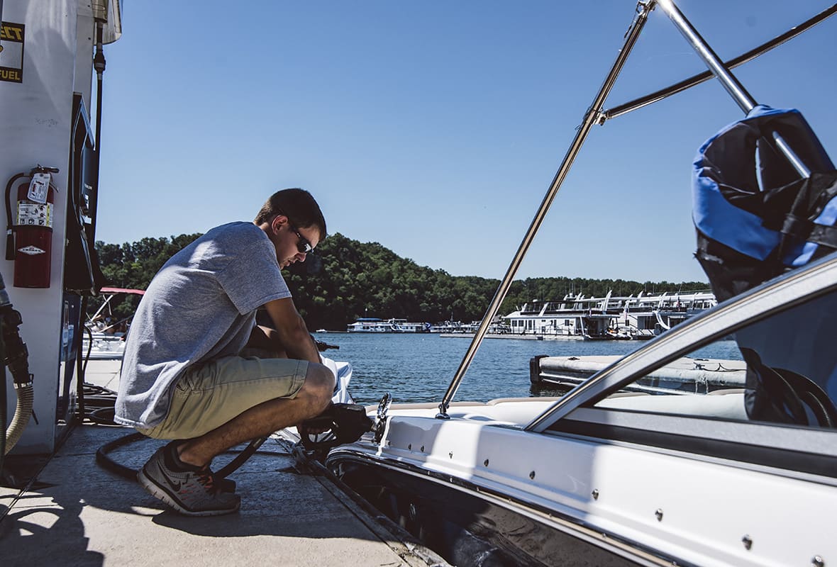 Employee filling up boat at fuel dock
