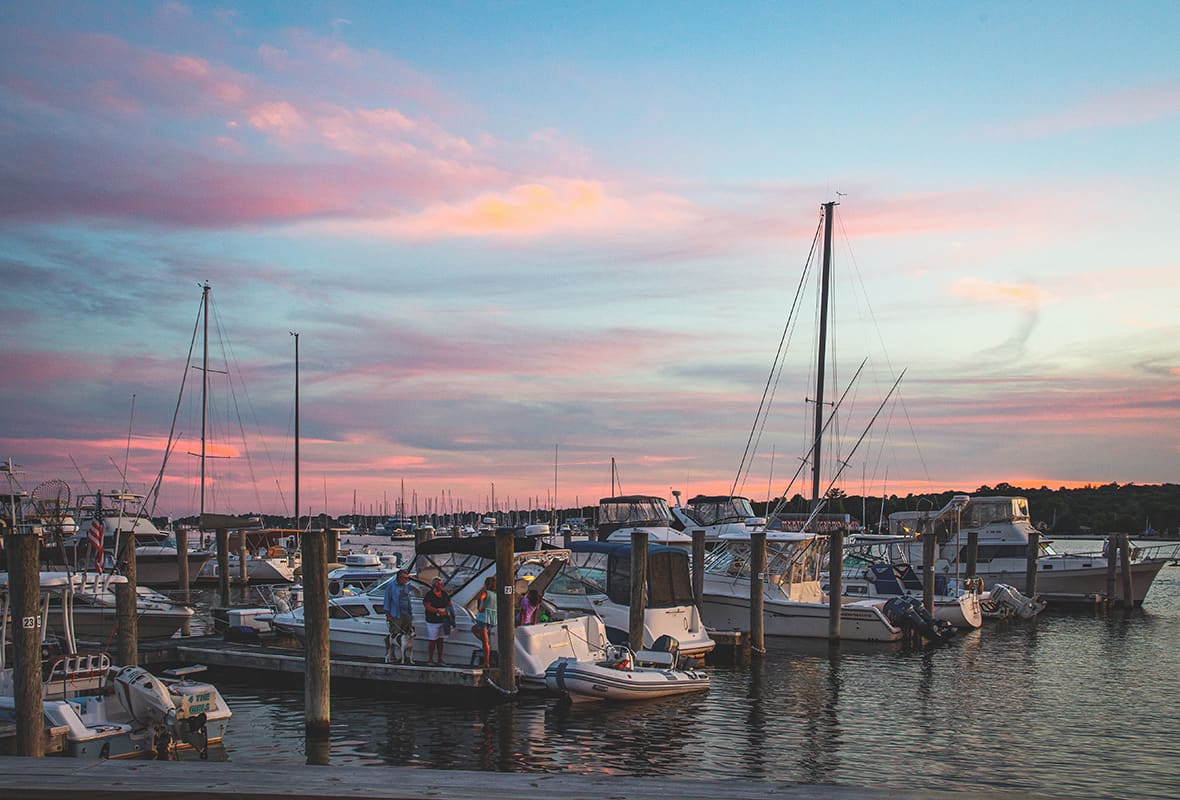 Boats docked at marina at sunset